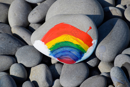 彩绘的石头石头上画着的彩虹花彩绘的石头石头上彩绘的彩虹背景图片
