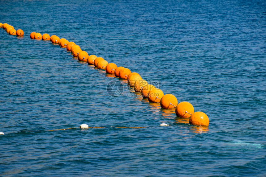 海上一条绳子的橙色浮标海上游泳的栅栏