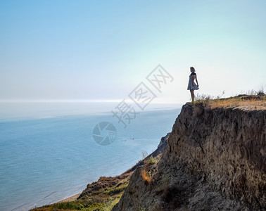女孩站在海边悬崖上图片