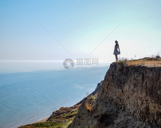 女孩站在海边悬崖上图片