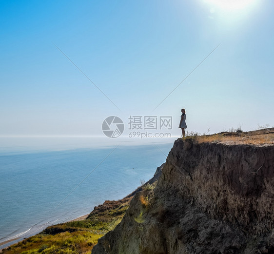 女孩站在海边悬崖上图片