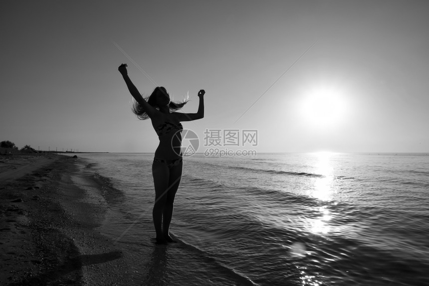 一个女孩在海边夕阳下的剪影大海夕阳映衬下的黑影晚上海滩上的女孩海边夕阳映衬下的女孩剪影图片