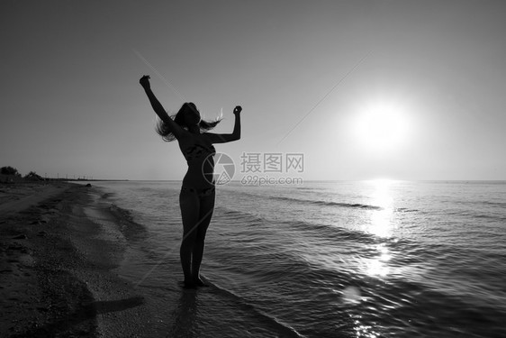 一个女孩在海边夕阳下的剪影大海夕阳映衬下的黑影晚上海滩上的女孩海边夕阳映衬下的女孩剪影图片