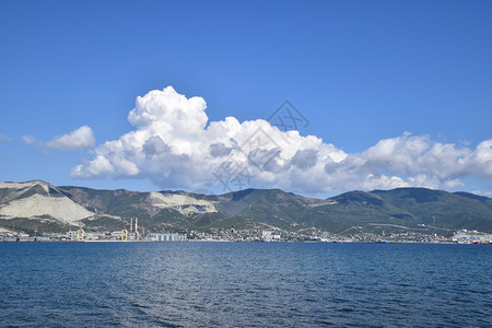 海湾风景Tsemes山地和天空中的云层远处可以看到海洋货运港湾风景Tsemes山地和天空中的云层远处可以看到海洋货运港图片