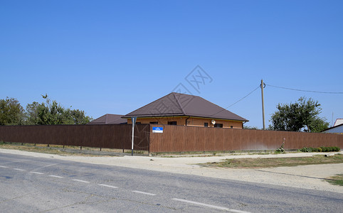一栋房屋有金属顶用棕色金属壁画制成的栅栏一栋房屋用棕色金属壁画制成的栅栏图片