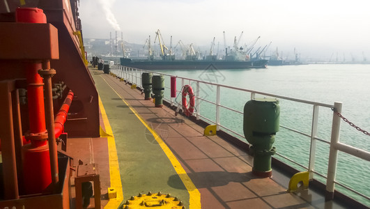港口码头海和城市滩的景象工业港口有塔起重机和货物基础设施图片