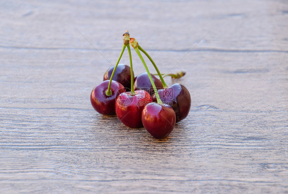 木质背景上的樱桃浆果成熟的红甜樱桃木质背景上的樱桃浆果成熟的红甜樱桃图片