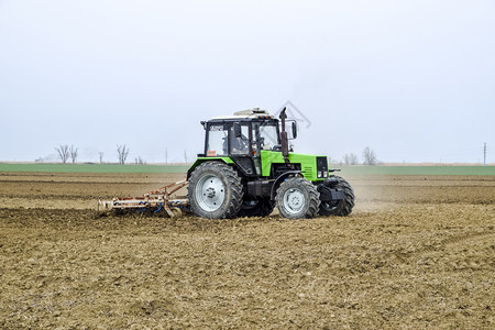 俄罗斯Krasnodar附近的田地2018年3月日在播种前拉和松开田地上的土壤拖拉机用犁耕田和松开地上的土壤然后播种拖拉机用犁耕图片
