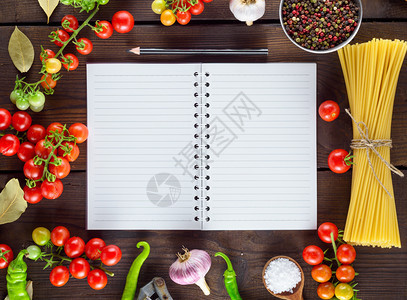 一根线条的开放空白笔记本和黑木铅意大利面蔬菜和香料烹饪的原图片
