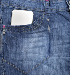 蓝牛仔裤前口袋的智能手机全框图片