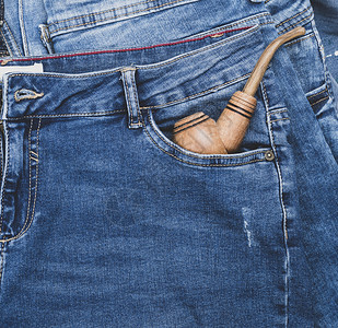 烟用木制管放在蓝牛仔裤前口袋里图片