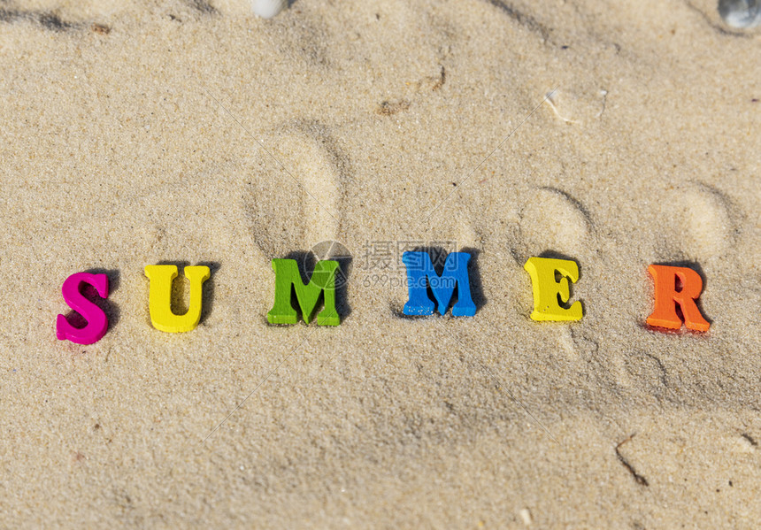 夏季用多色木字母在沙上顶视图图片