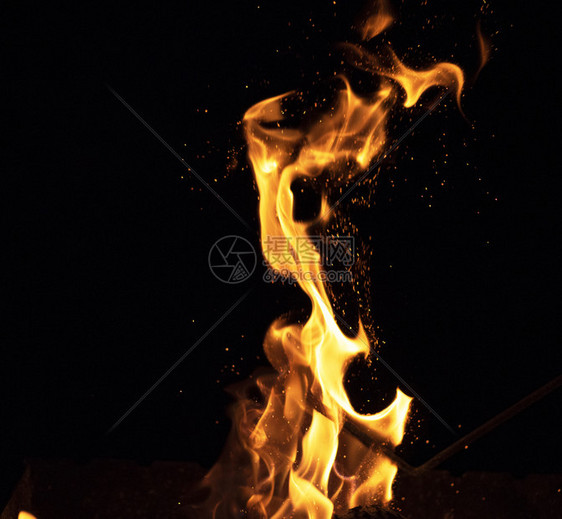 黑色背景上燃烧的木和大橙色火焰图片
