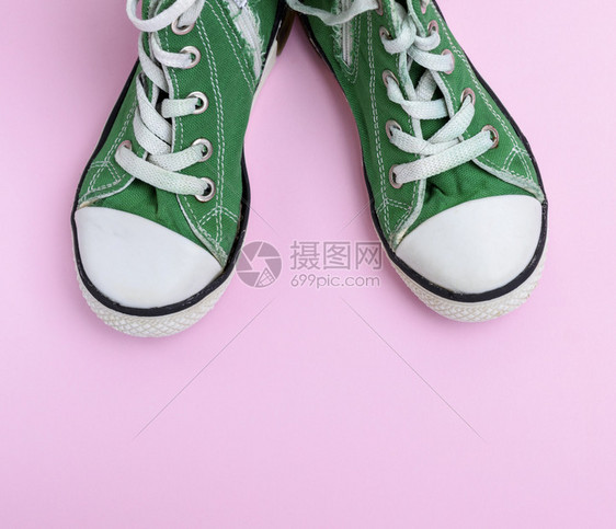 粉红背景的一对绿色儿童鞋顶部视图图片