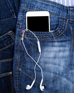 白智能手机空黑屏幕耳机放在蓝牛仔裤前口袋关闭图片