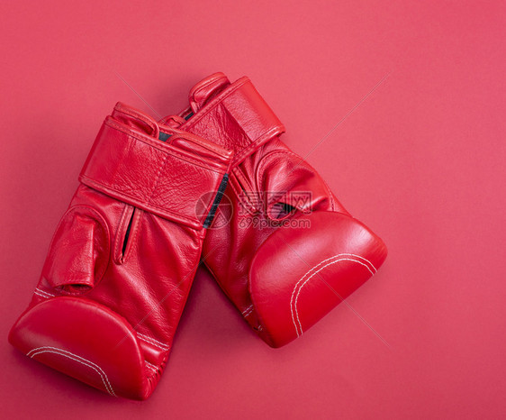 红色背景顶视图复制空间上的新红运动皮衣拳击手套图片