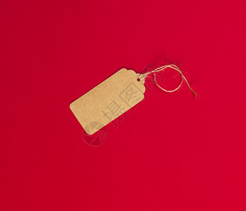 一根绳索上衣服的空棕色纸标签位于红背景上图片