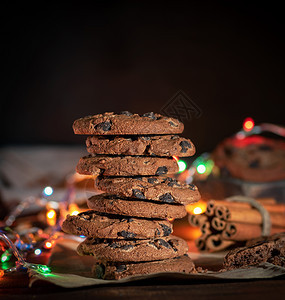 整堆圆巧克力饼干在圣诞园的燃烧灯光后面图片