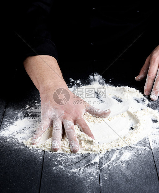 黑木桌上的白面粉和厨师准备打折面粉图片