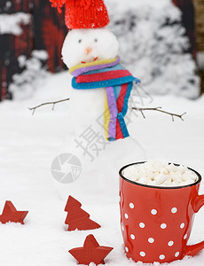 红瓷杯加热巧克力和棉花糖雪中一个快乐的人身后图片