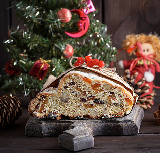 一颗带有坚果和罐头水的传统欧洲蛋糕在棕色木板上涂有糖粉和图片