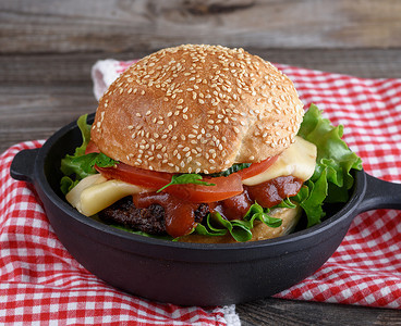 带肉丸和蔬菜的汉堡包黑圆铁煎锅关门图片