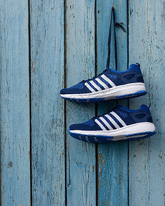 蓝色木墙上的一对男蓝色纺织运动鞋图片