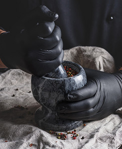 黑乳胶大厨手套上装有石迫击混合胡椒烹饪和研磨香料图片