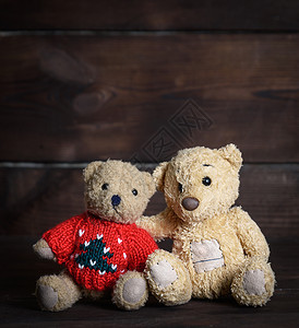 两只小棕色软泰迪熊坐在木表面上紧闭图片