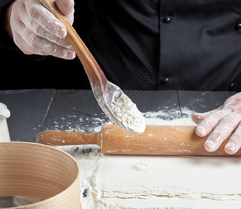 木勺子和白面粉由厨师亲手制成面粉图片