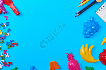 蓝背景儿童有塑料玩具铅笔气球和英文字母空间的木字母图片