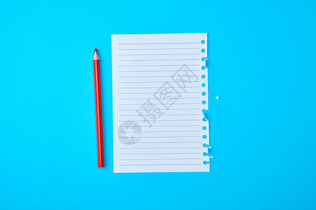 蓝色背景上的笔记本和木红色铅笔被撕破图片