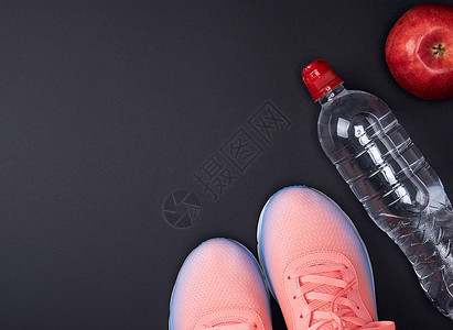 粉红运动鞋和黑色背景水瓶最高视图图片