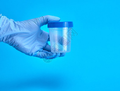 戴空塑料罐子的手套用于验血蓝底图片