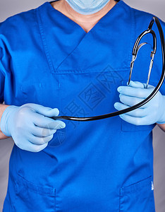穿着蓝色制服和乳胶手套的医生戴着黑色听诊器关上图片