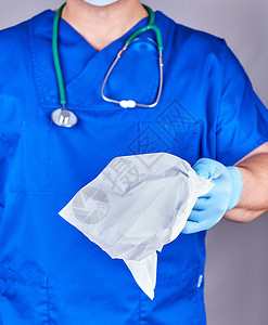 蓝制服医生和无菌乳胶手套带有面部和身体白纸组织图片