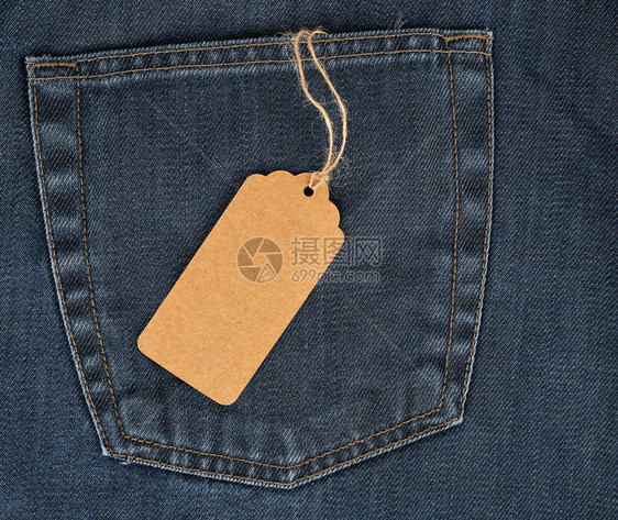 绑在绳子上是蓝色牛仔裤上一个空白的长方形棕色纸标签全框图片