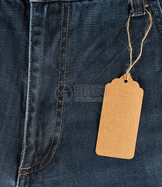绑在绳子上是蓝色牛仔裤上一个空白的长方形棕色纸标签全框图片