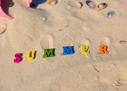 夏季用多色木字母在沙上顶视图图片