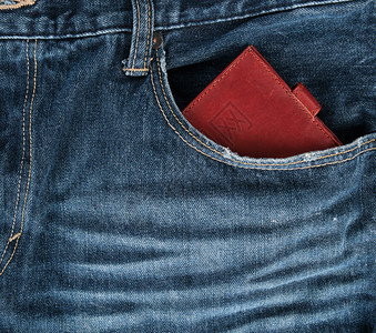 蓝牛仔裤前口袋的棕色皮钱包全框图片