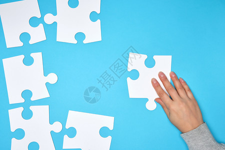 蓝色背景的白大空拼图女手将数字成功概念联系起来图片