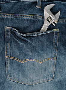 穿蓝色牛仔裤的金属可调整扳手全框图片