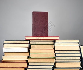 一串灰色背景的不同书籍红色装订的顶部图片