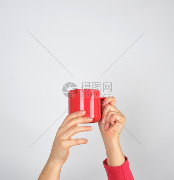 女手握红色陶瓷杯灰背景图片