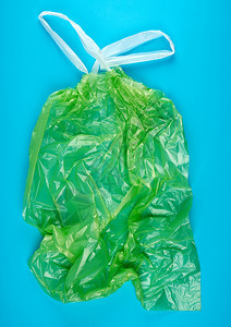 蓝色背景有把手的空绿色塑料垃圾袋图片