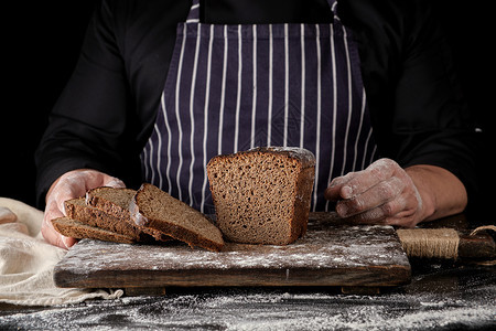 黑制服厨师衣烤麦面包棕色木板上涂满黑底白面粉图片