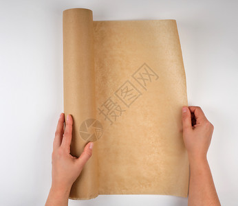 女手中的棕色纸卷白背景顶部视图图片