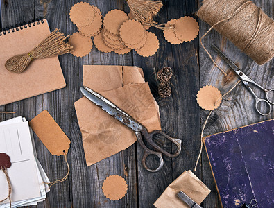 棕色绳索纸标签和灰色木背景的旧剪刀用于制作手工艺品的物图片