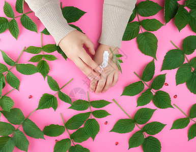 两只雌手厚奶油和绿莓树叶顶级观点重振和润湿手皮的抗老化程序概念图片
