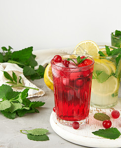 一杯白木板上清夏的草莓和红后面是黄柠檬和绿薄荷叶图片